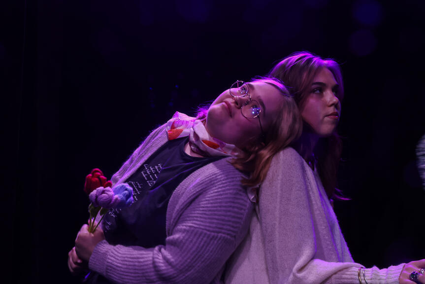 Kaksi henkilöä nojaavat toisiinsa selät vastakkain