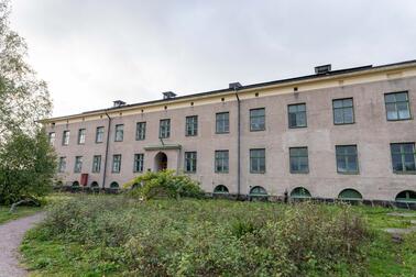 Suuri ruskeanharmaa taiteilijatalo edestäpäin kuvattuna.