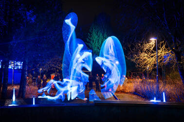 Pimeässä illassa otettu kuva, jossa värillisiä valoja ja liikettä.