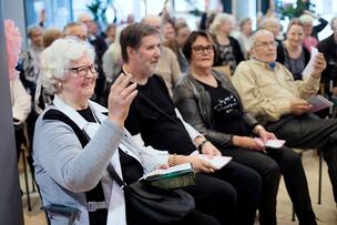 Människor sitter på stolar vid ett diskussionsmöte.