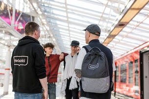 Fyra unga står på en tunnelbanestation och pratar.