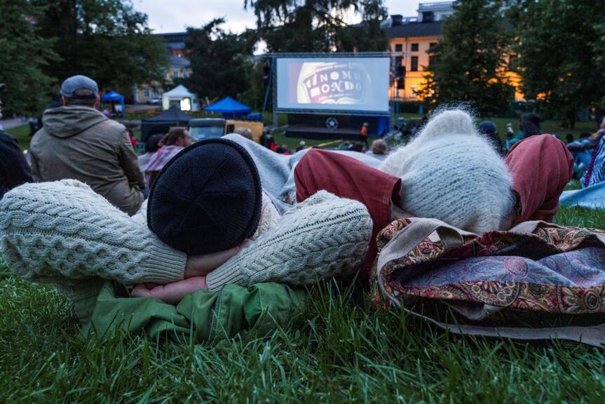 Två personer tittar på en utomhusfilm.
