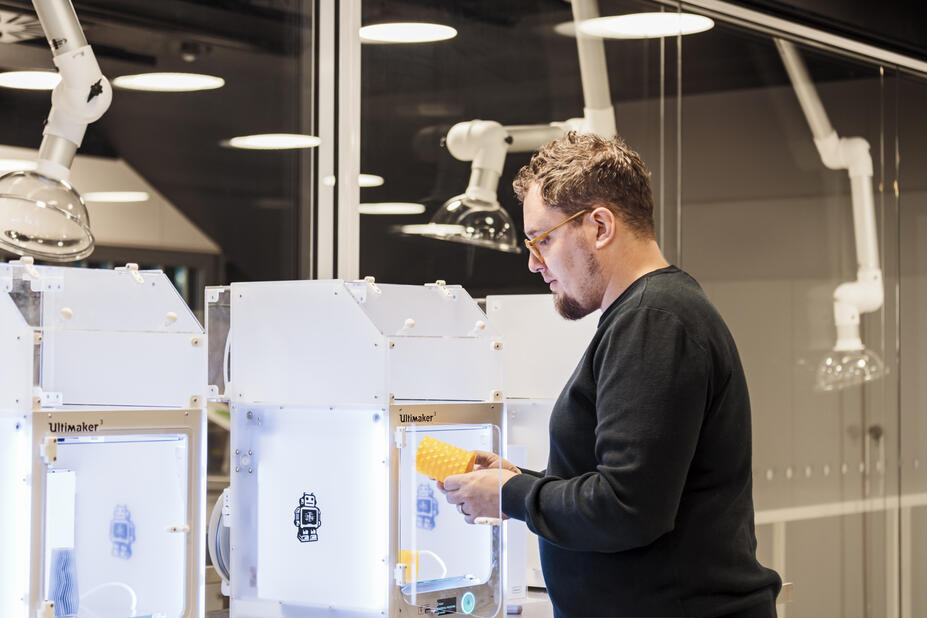 Henkilö käyttää 3D-tulostinta.