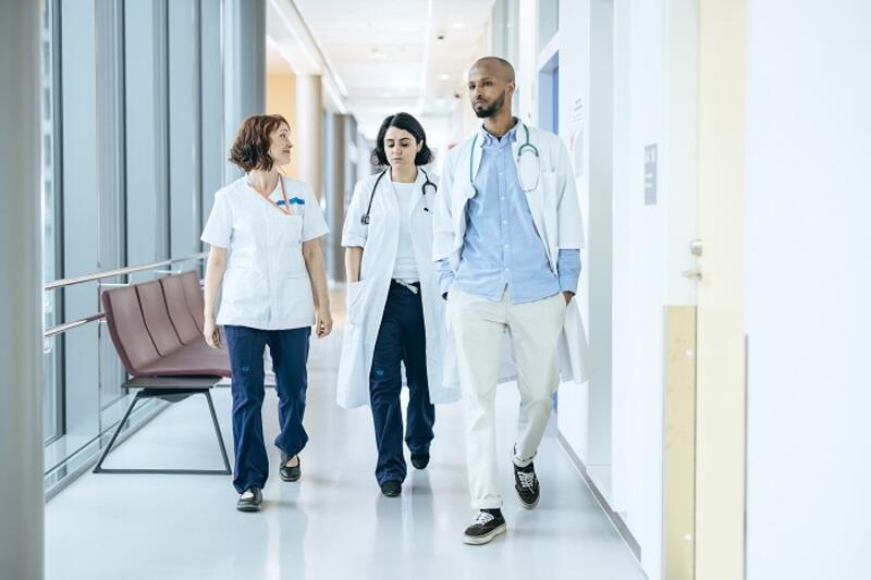Lääkäreitä ja sairaanhoitajia kävelee käytävällä.